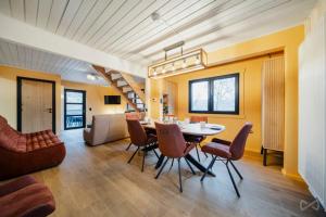 a dining room and living room with a table and chairs at Gites Douillets Chalet du Vicomte in Houyet