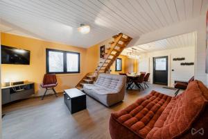 a living room with a couch and a spiral staircase at Gites Douillets Chalet du Vicomte in Houyet