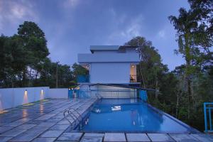 a house with a swimming pool in front of a house at Nature Shade Pool Villa in Anachal