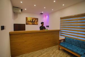 a man standing at a counter in a waiting room at Nature Shade Pool Villa in Anachal