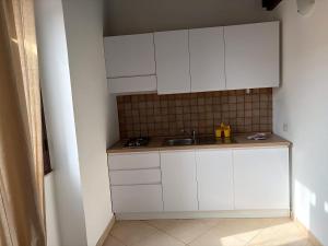 a kitchen with white cabinets and a sink at Appartamenti PIAZZA BIANCA in Lampedusa