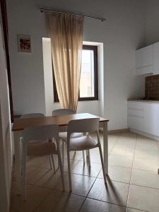 a kitchen with a table and chairs and a window at Appartamenti PIAZZA BIANCA in Lampedusa