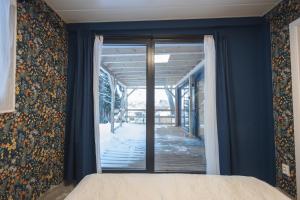 a bedroom with blue walls and a large glass door at Luxury Home in Igal