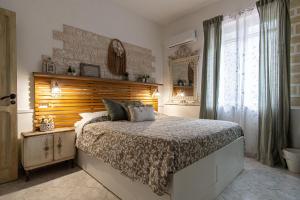 a bedroom with a bed with a wooden headboard at Grotta dei Puntali B&B in Carini