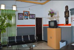 a room with a couch and a tv on a cabinet at Hotel SIDAPORE in Lamobuang