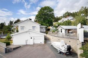 a house with a garage and a boat on a driveway at Exclusive villa with a stunning view in Sigtuna