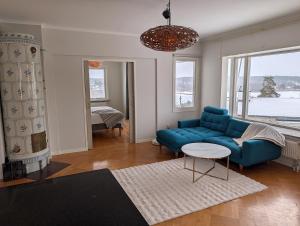 a living room with a blue couch and a table at Exclusive villa with a stunning view in Sigtuna +17 photos