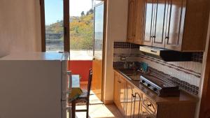 a kitchen with a sink and a counter with a window at Deda Apartaments in Shëngjin