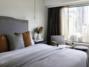 a bedroom with a bed with a window and a chair at Pullman Sydney Hyde Park in Sydney +89 photos