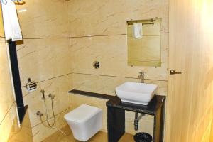 a bathroom with a white sink and a toilet at Hotel Samrat International in Mount Ābu +48 photos