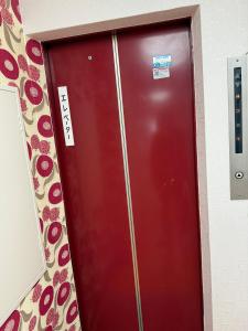 a red elevator door in a room with flowers at 亀井町Stay501 in Takamatsu