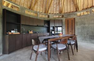 a kitchen with a large wooden table and chairs at Babakan Hill Villas in Jasri