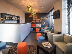 a lobby with a bar with a camel painting on the wall at ibis Styles Saumur Gare Centre in Saumur