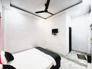 a white room with a bed and a ceiling fan at New Amar Palace Shimla with Mountain View in Shimla