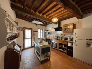 a large kitchen with a refrigerator and a stove at TRUFFLE'N'BED in San Giovanni dʼAsso