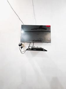 a flat screen tv hanging from a white wall at New Amar Palace Shimla with Mountain View in Shimla +16 photos