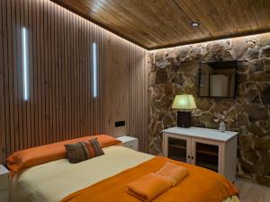 a bedroom with a bed and a stone wall at Casa Axier - Piscina Privada - Aire Acondicionado - Barbacoa in Biar +91 photos