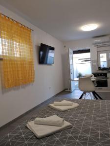 a room with two towels on the floor with a television on the wall at Lorber house Štinjan - Studio in Pula