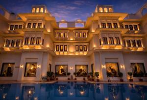 a large building with a pool in front of it at Swaroop Vilas - Lake Facing Boutique Hotel in Udaipur