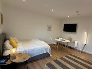 a bedroom with a bed and a table and a tv at Deich Quartier 9.2 in Dorum-Neufeld