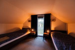 two beds in a room with a window and two candles at Kajaki wino i śpiew - domek z sauną w otoczeniu lasów i sąsiedztwie zalewu in Zakrzówek Szlachecki