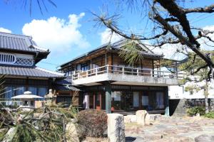 a house with a balcony on top of it at Okayama Hostel Igusa in Hayashima +39 photos