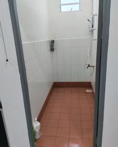 a bathroom with a shower and a tiled floor at Cem Miri Homestay 2 in Miri