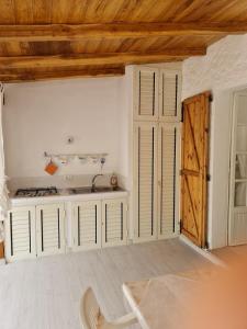 a kitchen with white cabinets and a wooden ceiling at Casa Bruna in San Teodoro