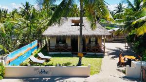 a house on the beach with a straw roof at Casa Regina in Vilanculos