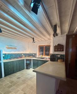 a kitchen with green cabinets and a ceiling with blue lights at Hoûch Les Anartistes in Erriadh