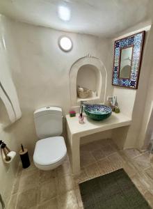 a bathroom with a white toilet and a sink at Hoûch Les Anartistes in Erriadh +35 photos