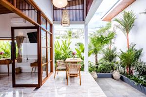 a patio with a table and chairs and plants at Sake Bali Suites in Tegalalang