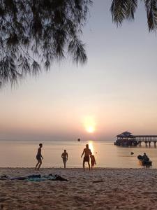a group of people playing with a ball on the beach at Maya Seaview Chalet, Coral Bay Perhentian Island in Perhentian Island