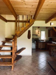 a kitchen with a wooden staircase in a house at Domek nad Wiarem in Huwniki