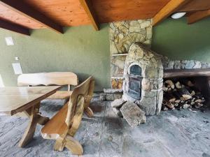 a stone fireplace in a room with a table and bench at Domek nad Wiarem in Huwniki +20 photos