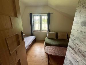 a small room with a bed and a window at Domek nad Wiarem in Huwniki