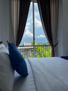 a bedroom with a bed with a large window at Kandy Alpine Breeze in Kandy