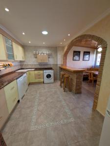 a large kitchen with a counter and a table at Casa Axier - Piscina Privada - Aire Acondicionado - Barbacoa in Biar