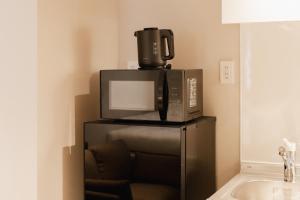 a microwave sitting on top of a black refrigerator at Hotel SHUTEC in Kagoshima +36 photos