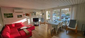 a living room with a red couch and a table at Holiday Home in Thyholm