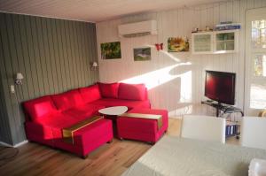 a living room with a red couch and a table at Holiday Home in Thyholm +30 photos