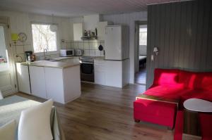 a kitchen with white appliances and a red couch at Holiday Home in Thyholm