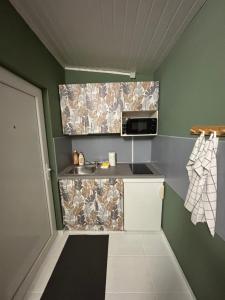 a small kitchen with a sink and a microwave at Home for two in Igal +3 photos