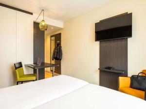 a hotel room with a bed and a desk and a tv at ibis Styles Hotel Brussels Centre Stéphanie in Brussels