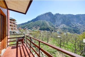 a balcony with a chair and a view of a mountain at Royal Ocean COTTAGE in Manāli