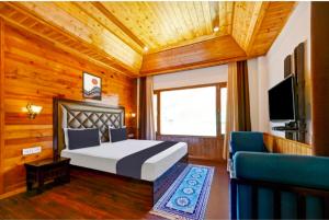 a bedroom with a bed and a tv and a couch at Royal Ocean COTTAGE in Manāli