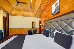 a bedroom with a large bed in a room at Royal Ocean COTTAGE in Manāli +4 photos
