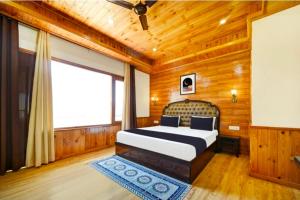 a bedroom with a bed and a large window at Royal Ocean COTTAGE in Manāli