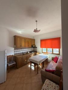 a kitchen with a table and a dining room at Deda Apartaments in Shëngjin +14 photos