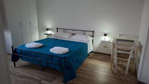 a bedroom with a blue bed with two towels on it at b&b Vitae in Tremensuoli